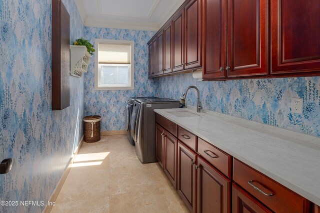 clothes washing area with a sink, separate washer and dryer, wallpapered walls, cabinet space, and crown molding