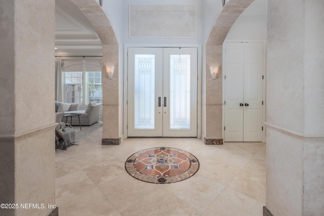 entrance foyer featuring arched walkways and french doors
