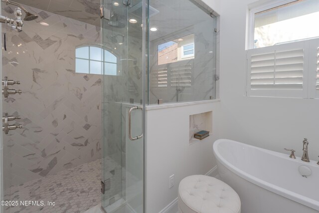 full bath featuring a shower stall and a freestanding tub