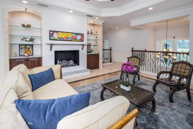 living area featuring crown molding, built in features, a decorative wall, and visible vents
