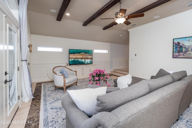 living room with a healthy amount of sunlight, beam ceiling, and visible vents
