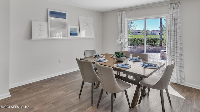 dining space with baseboards and wood finished floors