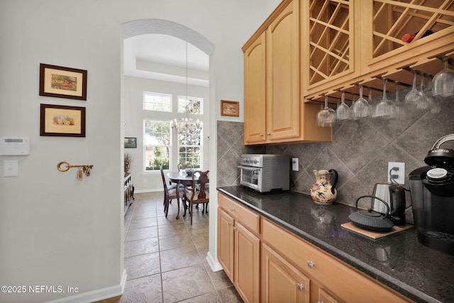 809 Ifield Rd, Saint Augustine, FL 32095 - kitchen featuring backsplash, baseboards, arched walkways, a chandelier, and light brown cabinets