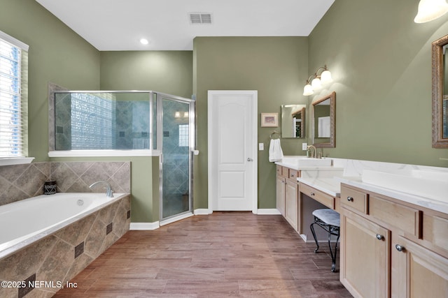 809 Ifield Rd, Saint Augustine, FL 32095 - full bathroom featuring a stall shower, vanity, a garden tub, wood finished floors, and baseboards