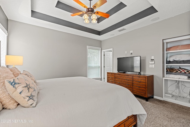 13111 Hammock Cir S, Jacksonville, FL 32225 - bedroom with a raised ceiling, carpet floors, multiple windows, and ceiling fan