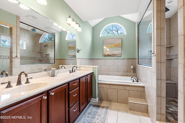 13111 Hammock Cir S, Jacksonville, FL 32225 - bathroom featuring double vanity, tile patterned flooring, vaulted ceiling, a bath, and a walk in shower