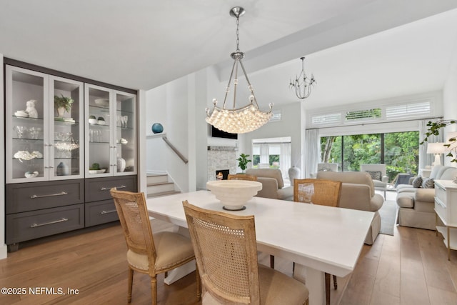 90 Players Club Villas Rd, Ponte Vedra Beach, FL 32082 - dining room with a chandelier, high vaulted ceiling, a lit fireplace, and wood finished floors