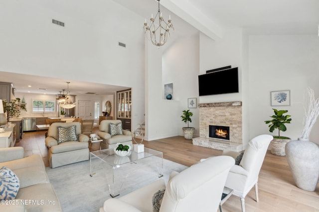 90 Players Club Villas Rd, Ponte Vedra Beach, FL 32082 - living area featuring high vaulted ceiling, visible vents, a fireplace, light wood finished floors, and a notable chandelier