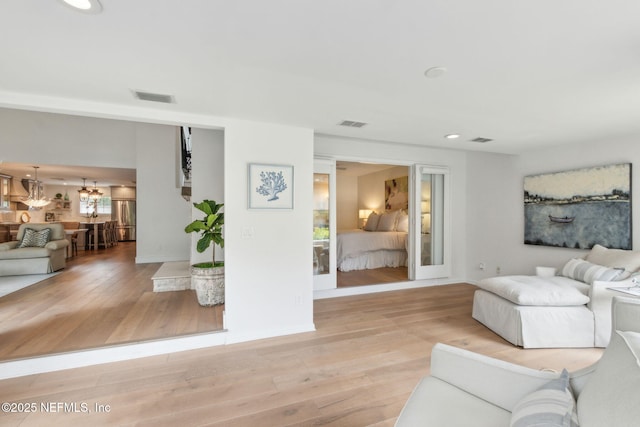 90 Players Club Villas Rd, Ponte Vedra Beach, FL 32082 - living room featuring light wood finished floors, an inviting chandelier, and visible vents