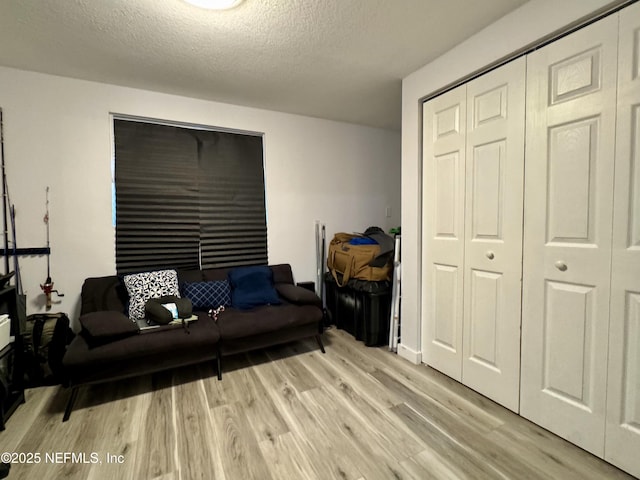 living area featuring light wood-style flooring and a textured ceiling