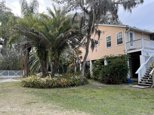 view of home's exterior featuring stairs and a lawn