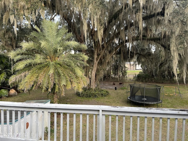 view of grassy yard featuring a trampoline