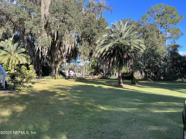 view of green lawn with view of scattered trees