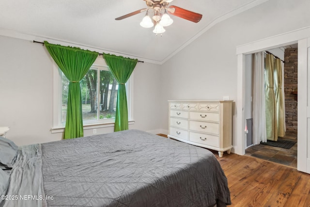 bedroom with vaulted ceiling, ornamental molding, a ceiling fan, and wood finished floors