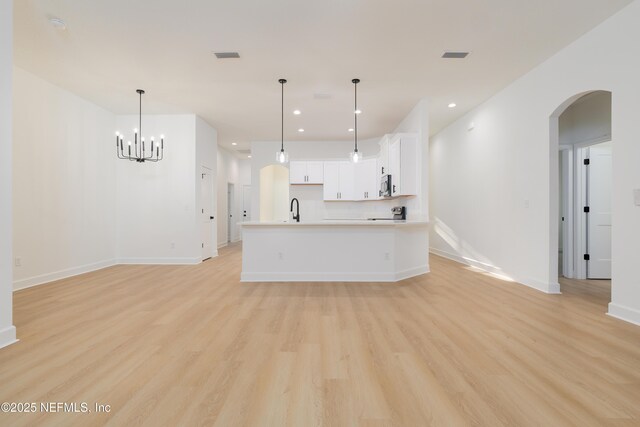 5821 Silver Sands Cir, Keystone Heights, FL 32656 - kitchen featuring arched walkways, light wood-style floors, open floor plan, and a sink