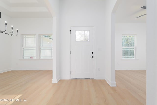 5821 Silver Sands Cir, Keystone Heights, FL 32656 - entrance foyer with light wood-style flooring, baseboards, arched walkways, and a notable chandelier