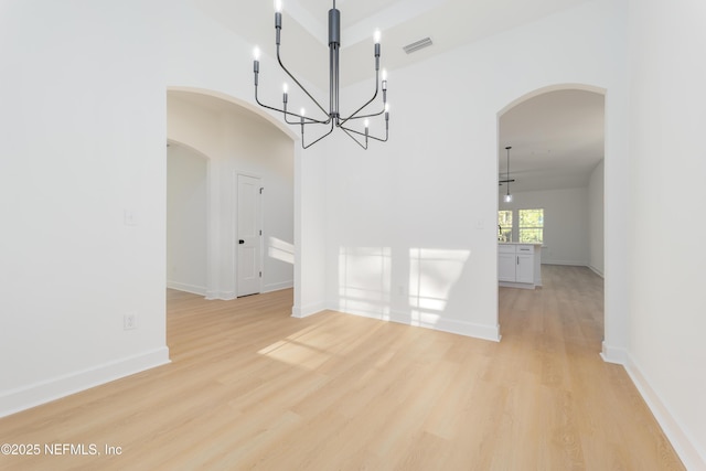 5821 Silver Sands Cir, Keystone Heights, FL 32656 - unfurnished dining area featuring light wood-type flooring, a notable chandelier, visible vents, and arched walkways