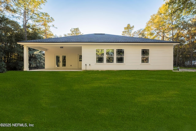 5821 Silver Sands Cir, Keystone Heights, FL 32656 - back of house featuring a patio area, a shingled roof, french doors, and a lawn