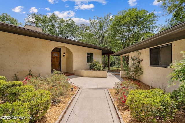 1315 Autumn Trce, Fernandina Beach, FL 32034 - property entrance with stucco siding, a chimney, and a patio