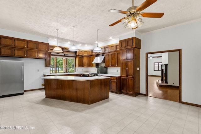 1315 Autumn Trce, Fernandina Beach, FL 32034 - kitchen with a ceiling fan, stainless steel refrigerator, baseboards, wall chimney exhaust hood, and light countertops