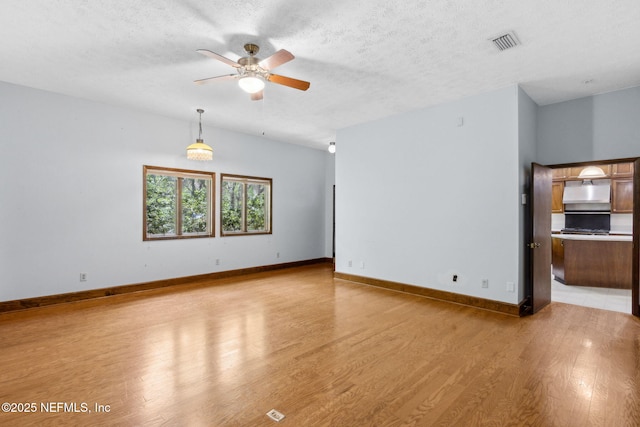1315 Autumn Trce, Fernandina Beach, FL 32034 - unfurnished living room featuring light wood-type flooring, visible vents, ceiling fan, and a textured ceiling