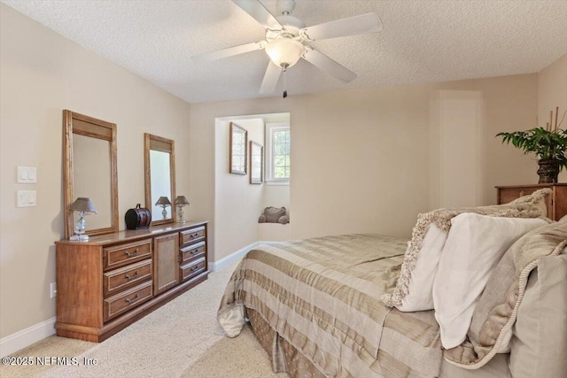 bedroom with light colored carpet, a textured ceiling, baseboards, and a ceiling fan