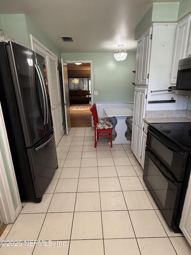 9252 San Jose Blvd Unit 3802, Jacksonville, FL 32257 - kitchen with range, stainless steel microwave, freestanding refrigerator, light countertops, and white cabinets