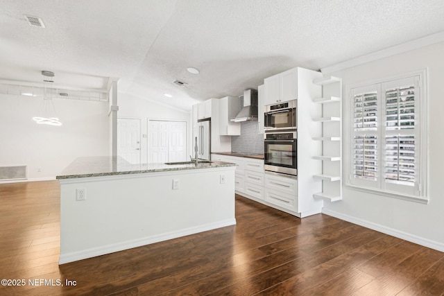 kitchen featuring wall chimney range hood, a textured ceiling, dark wood-style floors, high end refrigerator, and vaulted ceiling
