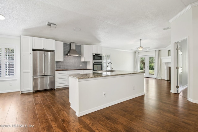 kitchen with stainless steel appliances, a textured ceiling, a ceiling fan, crown molding, and dark wood-type flooring