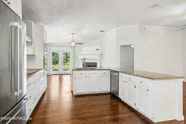kitchen featuring stainless steel appliances, ceiling fan, a sink, ornamental molding, and dark wood-type flooring