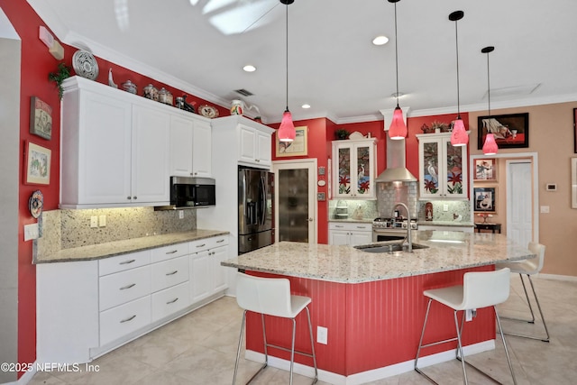 112 Long Branch Way, Saint Augustine, FL 32086 - kitchen with stainless steel microwave, a sink, wall chimney exhaust hood, black fridge, and backsplash