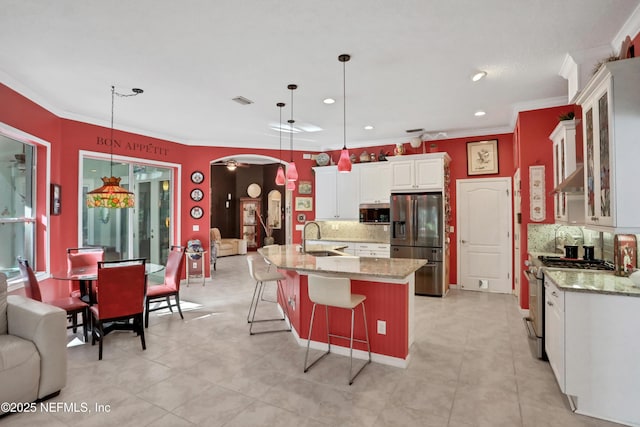 112 Long Branch Way, Saint Augustine, FL 32086 - kitchen with a breakfast bar area, ornamental molding, arched walkways, backsplash, and stainless steel appliances