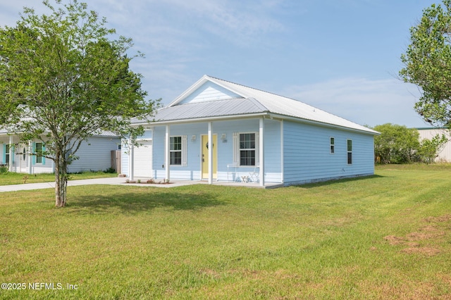109 N Peachtree St, Hastings, FL 32145 - view of front of house featuring covered porch, driveway, a front lawn, metal roof, and a garage