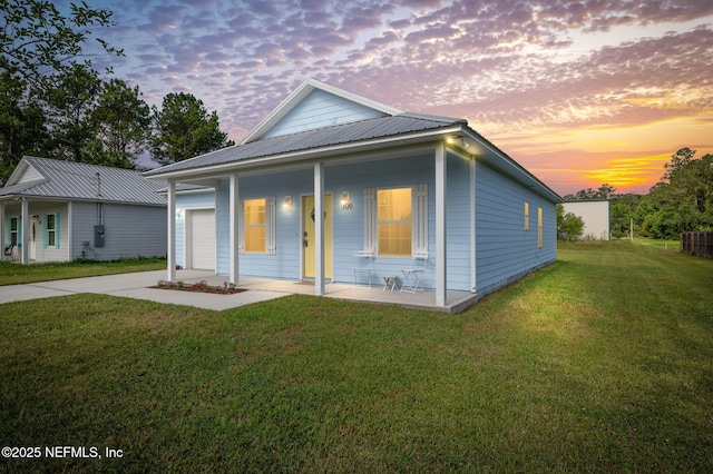 109 N Peachtree St, Hastings, FL 32145 - rear view of property with driveway, a yard, a garage, metal roof, and covered porch