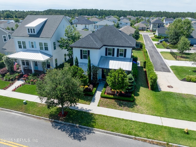 view of front of property with a residential view, metal roof, and a front lawn