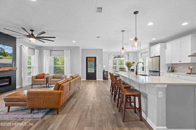 kitchen featuring freestanding refrigerator, light countertops, a sink, baseboards, and recessed lighting