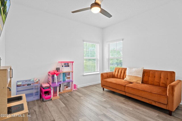 rec room featuring wood finished floors, a ceiling fan, and baseboards