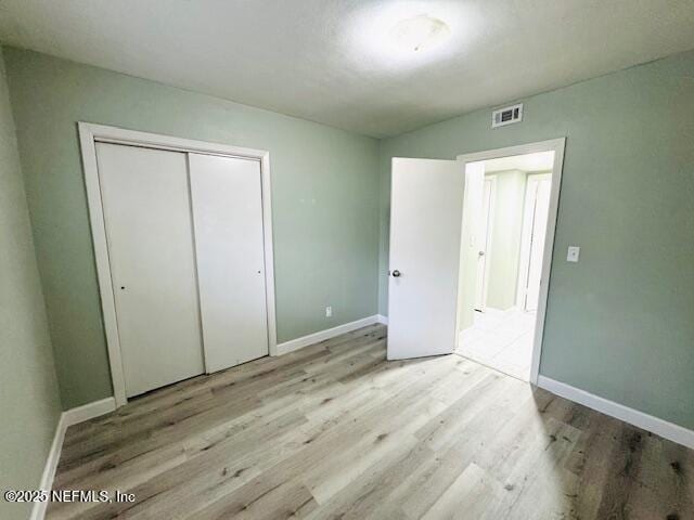 6332 Badnur Dr, Jacksonville, FL 32210 - unfurnished bedroom with wood finished floors, baseboards, and a closet