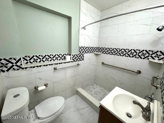 6332 Badnur Dr, Jacksonville, FL 32210 - bathroom featuring tiled shower, toilet, marble look tiles, and vanity