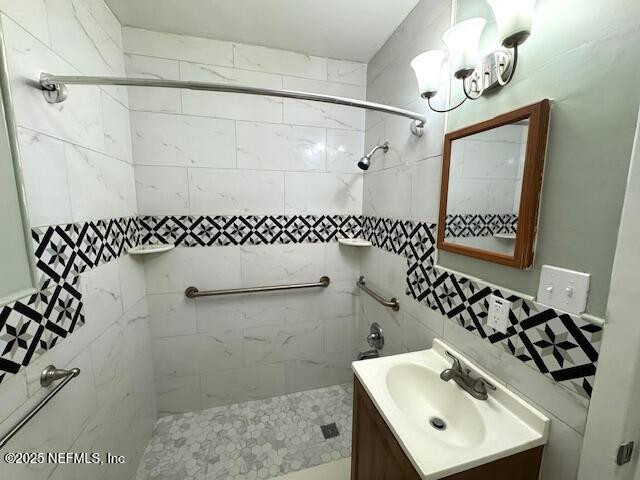 6332 Badnur Dr, Jacksonville, FL 32210 - full bathroom featuring a tile shower, vanity, tile walls, and a chandelier