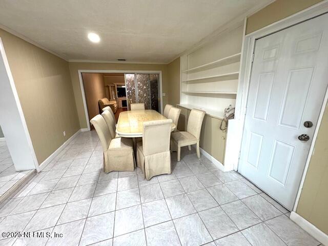 6332 Badnur Dr, Jacksonville, FL 32210 - dining room with crown molding, light tile patterned floors, baseboards, and recessed lighting