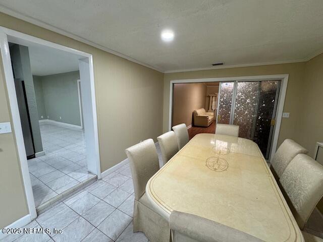6332 Badnur Dr, Jacksonville, FL 32210 - dining area featuring ornamental molding, baseboards, and light tile patterned floors