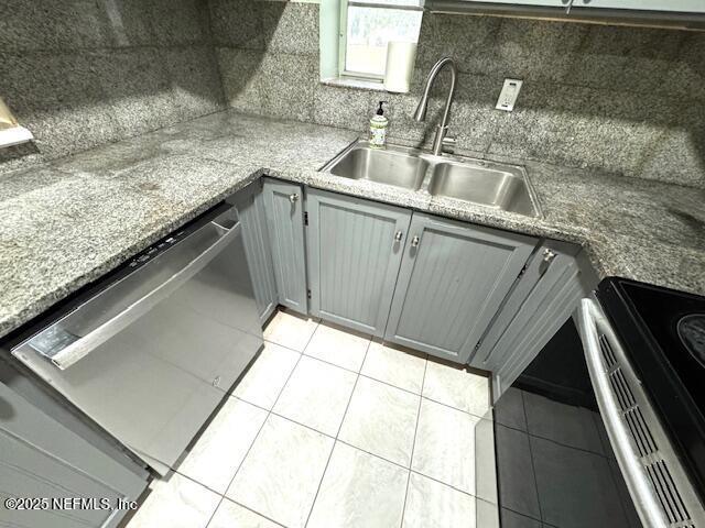 6332 Badnur Dr, Jacksonville, FL 32210 - kitchen with stainless steel appliances, a sink, gray cabinets, light tile patterned flooring, and tasteful backsplash