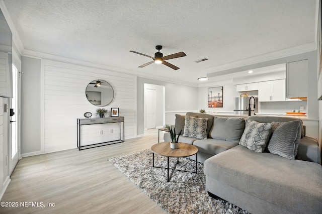 100 Fairway Park Blvd Unit 1809, Ponte Vedra Beach, FL 32082 - living area with crown molding, a ceiling fan, light wood finished floors, a textured ceiling, and baseboards