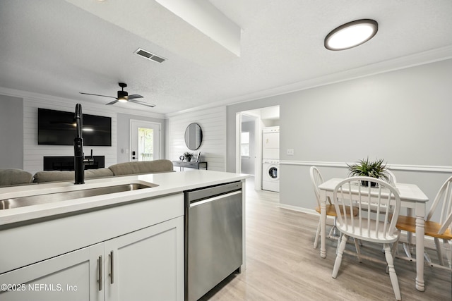 100 Fairway Park Blvd Unit 1809, Ponte Vedra Beach, FL 32082 - kitchen featuring stacked washing machine and dryer, dishwasher, a large fireplace, ornamental molding, and light countertops