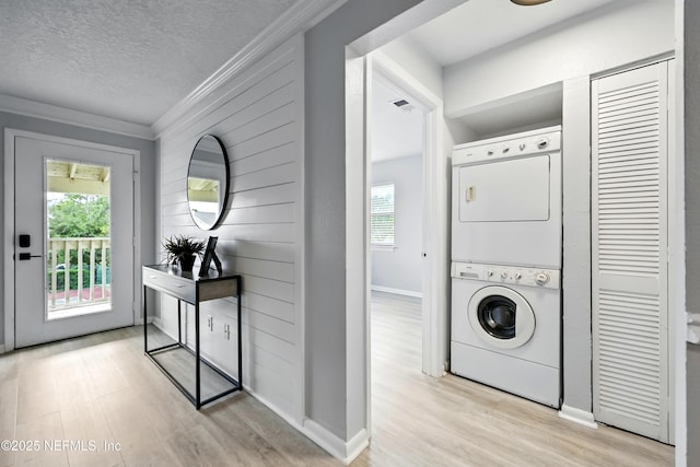 100 Fairway Park Blvd Unit 1809, Ponte Vedra Beach, FL 32082 - clothes washing area with stacked washer and clothes dryer, light wood finished floors, healthy amount of natural light, ornamental molding, and a textured ceiling
