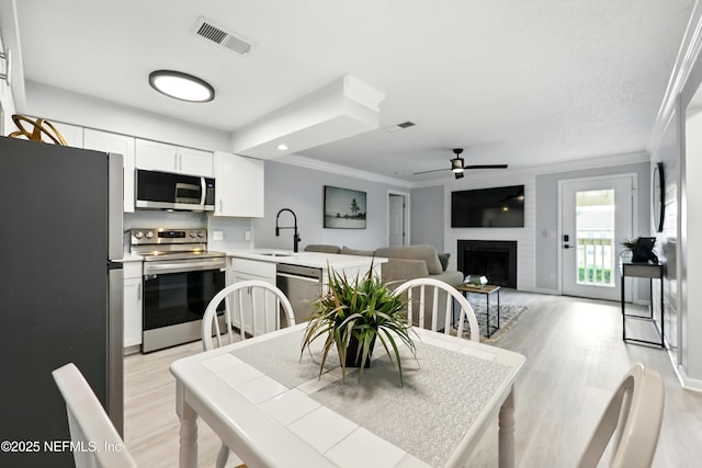 100 Fairway Park Blvd Unit 1809, Ponte Vedra Beach, FL 32082 - dining area with crown molding, light wood finished floors, a ceiling fan, and a large fireplace