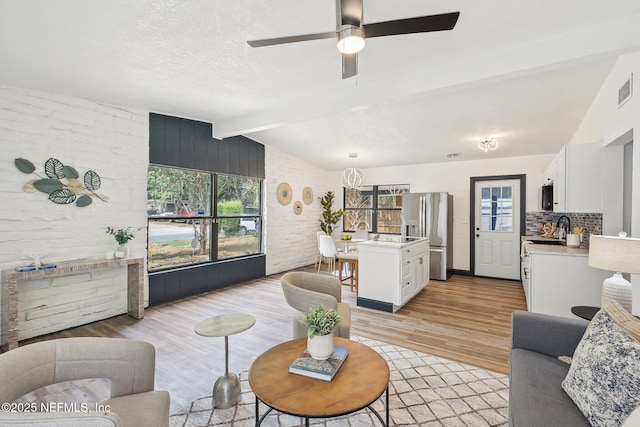 5444 Keystone Dr S, Jacksonville, FL 32207 - living room with plenty of natural light, light wood-style flooring, a ceiling fan, and a chandelier