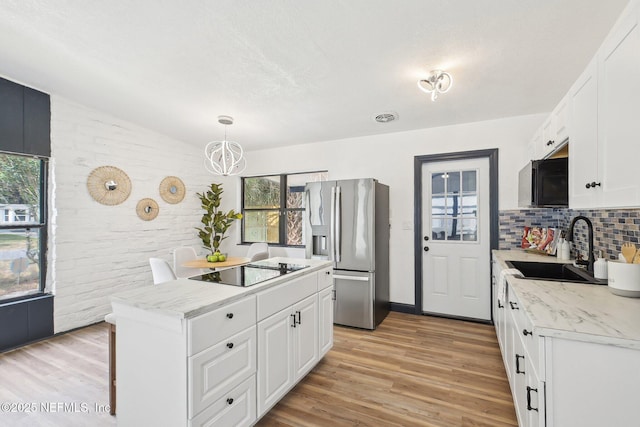 5444 Keystone Dr S, Jacksonville, FL 32207 - kitchen with stainless steel refrigerator with ice dispenser, black electric cooktop, lofted ceiling, light wood-type flooring, and a center island