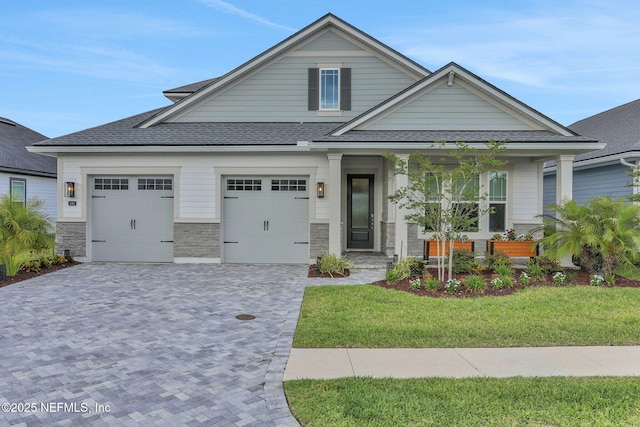 181 Lamego Ln, Saint Augustine, FL 32095 - craftsman-style house with covered porch, roof with shingles, a front lawn, and decorative driveway